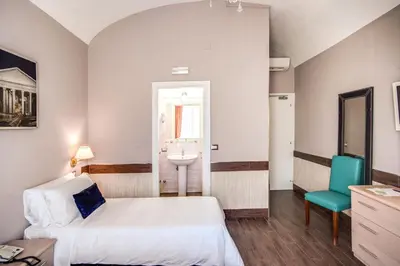a bedroom with a bed and a sink and a chair at Hotel San Valentino in Rome