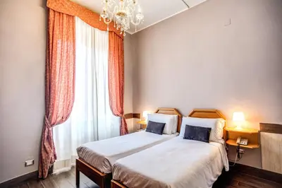 a bedroom with two beds and a chandelier and a window at Hotel San Valentino in Rome