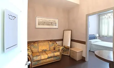 a living room with a chair and a bedroom at Hotel San Valentino in Rome
