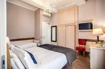 a bedroom with two beds and a chandelier at Hotel San Valentino in Rome