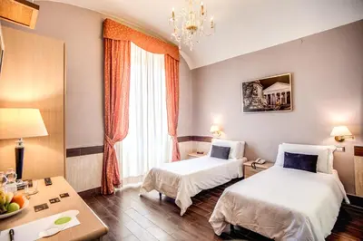 a hotel room with two beds and a table at Hotel San Valentino in Rome