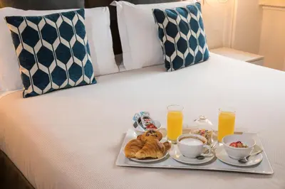 a tray of food with a teddy bear on a bed at Trastevere Gallery Suites in Rome