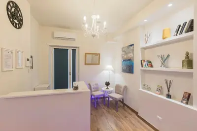 a waiting room with a counter and chairs and a clock at Trastevere Gallery Suites in Rome