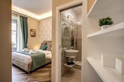 a bedroom with a bed and a bathroom with a sink at Dimore Vespasiano in Rome