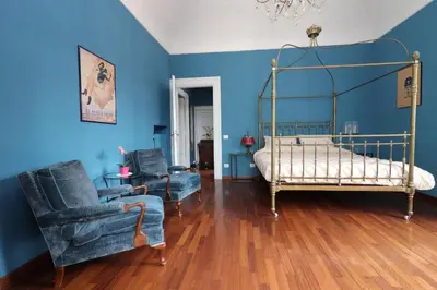 a bedroom with blue walls and a bed and two chairs at Trevi Grand Blu Suite B&B in Rome