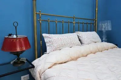 a bed in a blue bedroom with a red lamp at Trevi Grand Blu Suite B&B in Rome