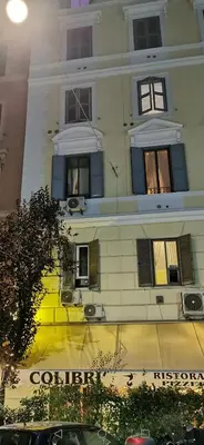 a tall white building with windows on a street at 109 SUITES ROMA in Rome