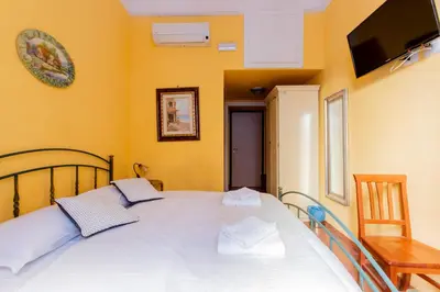 a bedroom with a white bed with a tv on the wall at Oscar 3 in Rome
