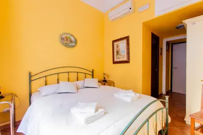 a bedroom with a large white bed with yellow walls at Oscar 3 in Rome