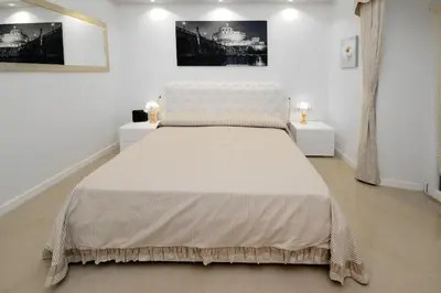 a white bedroom with a large bed with two night stands at Ludovisi Barberini Grand Apartment in Rome