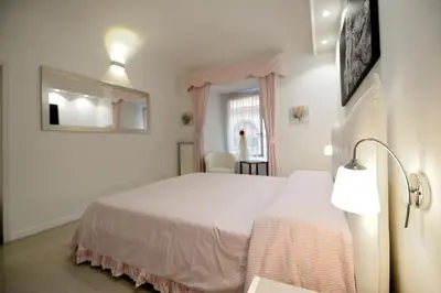 a bedroom with a white bed and a lamp at Ludovisi Barberini Grand Apartment in Rome