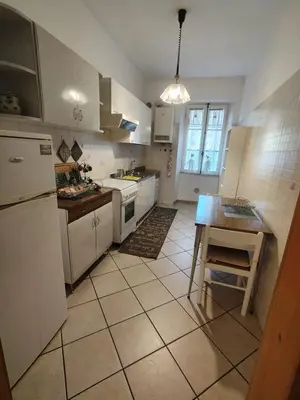 a kitchen with white appliances and a tiled floor at Appartament Piramide Cestia in Rome