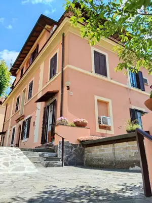 a peach colored building with stairs in front of it at Appartament Piramide Cestia in Rome