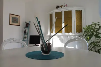 a vase with sticks in it sitting on a table at Appartament Piramide Cestia in Rome