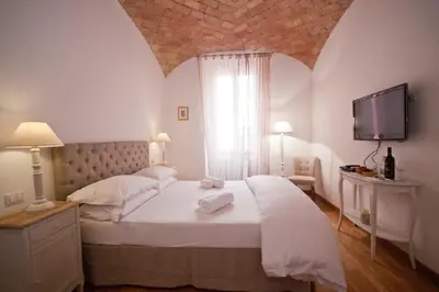 a bedroom with a large bed with a tv on the wall at La finestra sul Colosseo B&B 1 in Rome
