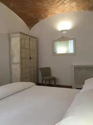 a bedroom with a white bed and a chair at La finestra sul Colosseo B&B 1 in Rome