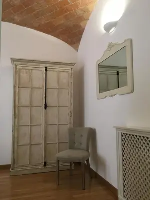 a chair in a room with a mirror on the wall at La finestra sul Colosseo B&B 1 in Rome