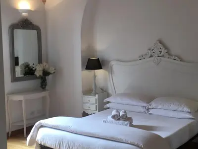 a white bedroom with a white bed and a mirror at La finestra sul Colosseo B&B 1 in Rome