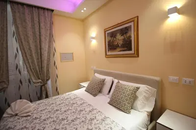 a small bedroom with a bed with pillows at Quest House Lihong in Rome