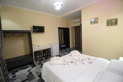 a hotel room with a bed and a desk at Quest House Lihong in Rome