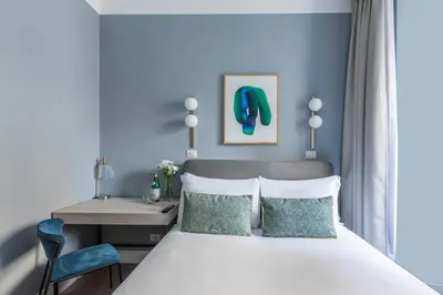a bedroom with a bed and a desk and a table at Numa Rome Linea in Rome