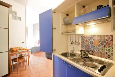a kitchen with blue cabinets and a sink and a table at Holiday flat in central location in Rome in Rome
