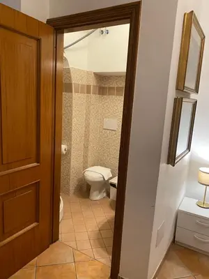 a bathroom with a toilet and a bathroom door at mini Apartment in Rome