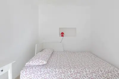 a white bedroom with a bed and a red light above it at Quiet with large terrace in Spanish Steps area in Rome