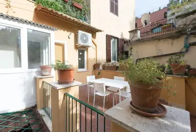 a balcony with a table and chairs on a building at Quiet with large terrace in Spanish Steps area in Rome