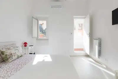 a white living room with a couch and a window at Quiet with large terrace in Spanish Steps area in Rome
