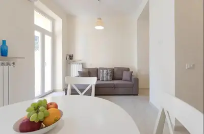 a white living room with a bowl of fruit on a table at Quiet with large terrace in Spanish Steps area in Rome