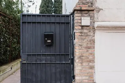 a black gate with a box on it next to a building at Angelina Apartment Roma Monteverde in Rome