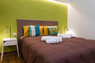 a bedroom with a large bed with two lamps on it at Angelina Apartment Roma Monteverde in Rome