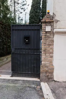 a black gate on the side of a house at Angelina Apartment Roma Monteverde in Rome