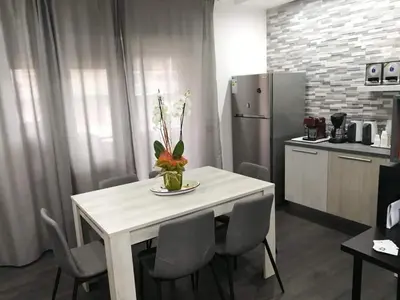 a kitchen with a white table with chairs and a refrigerator at Da Angelica in Rome