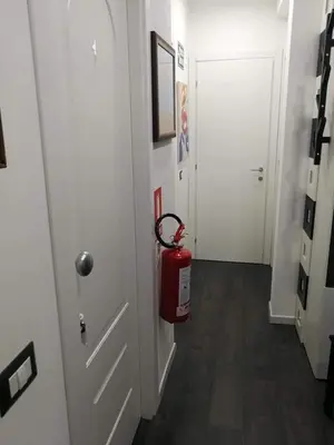 a red fire hydrant in a hallway with a door at Da Angelica in Rome