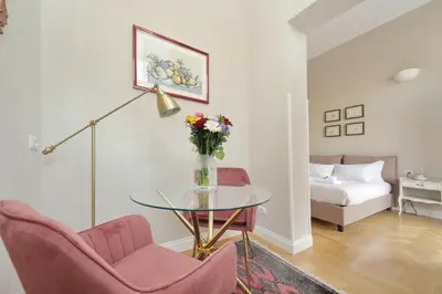 a room with a vase of flowers on a wall with mirrors at Beautiful suite in the heart of Trastevere in Rome