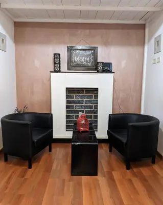 a living room with two chairs and a fireplace at Bed and Breakfast Zoe holiday in Rome