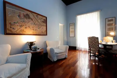 a living room with white chairs and a painting on the wall at Trevi Suite B&B in Rome