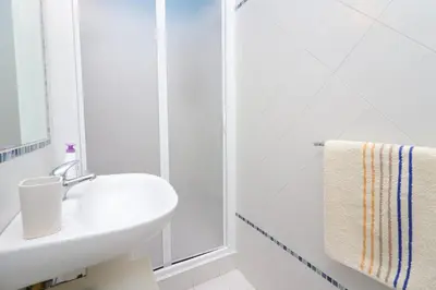 a white bathroom with a sink and a shower at Trevi Suite B&B in Rome