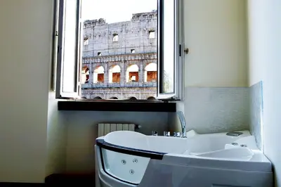 a bathroom with a tub and a window with the eiffel tower at jacuzzi in front of the colosseum in Rome