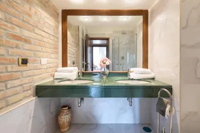 a bathroom with two sinks and a mirror at jacuzzi in front of the colosseum in Rome