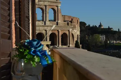 a vase with a blue bow sitting on a ledge in front of a building at Balcony Colosseum View in Rome