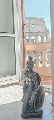 a statue sitting in front of a window at View Colosseo From Jacuzzi in Rome