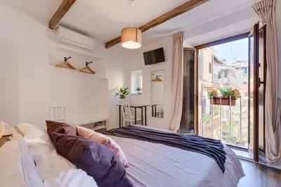 a bedroom with a bed and a large window at Domus De Fiori in Rome