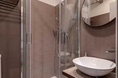 a bathroom with a sink and a glass shower at Domus De Fiori in Rome