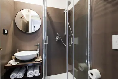 a bathroom with a shower with a sink and a mirror at Domus De Fiori in Rome