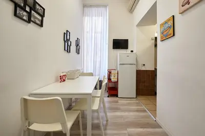 a kitchen with a white table and chairs and a refrigerator at Casa al Viminale in Rome