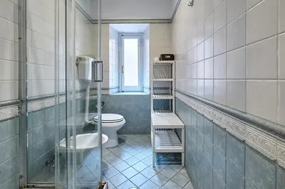 a bathroom with a toilet and a glass shower at Casa al Viminale in Rome