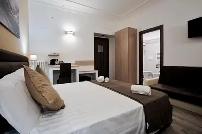 a bedroom with a large bed and a living room at Noemi's Rooms Guest House in Rome